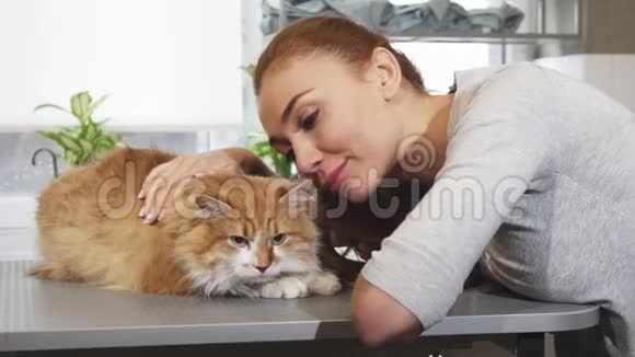 漂亮的女人和她的猫在兽医办公室微笑视频的预览图