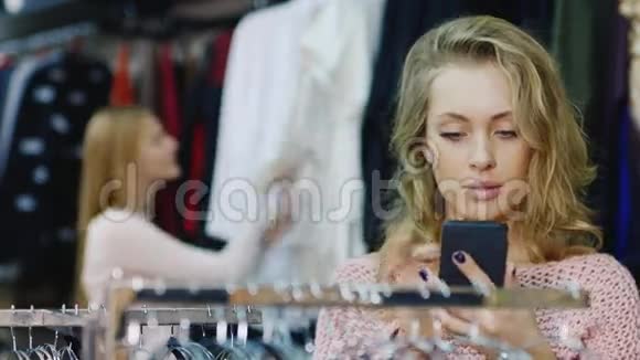 店里的顾客女装一个女人在你手机上看着一张照片拿起他的东西在视频的预览图