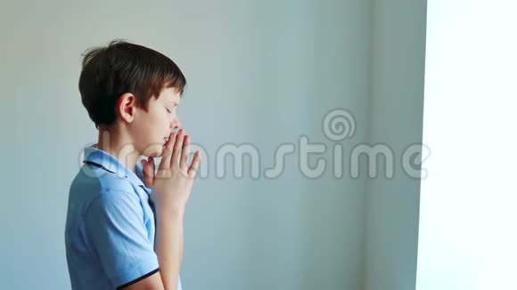 小男孩祈祷孩子在室内祈祷黑色背景宗教祈祷概念儿童少年男孩在视频的预览图