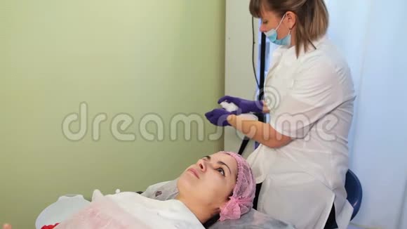 美容师在治疗前消毒双手女人躺在沙发水疗沙龙上接受水疗治疗的妇女视频的预览图
