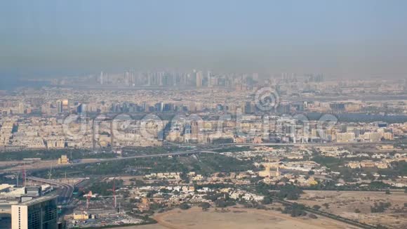 在阳光明媚的日子里迪拜和沙迦从哈利法塔俯瞰现代城市全景视频的预览图