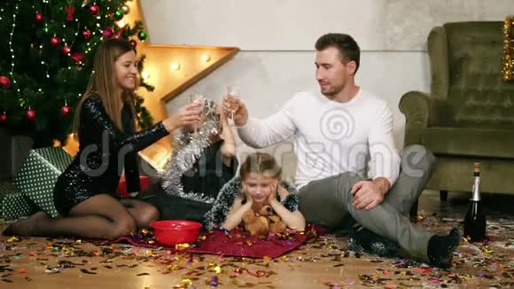 微笑的丈夫和他的妻子正在用香槟碰杯可爱的母亲父亲和两个女儿视频的预览图