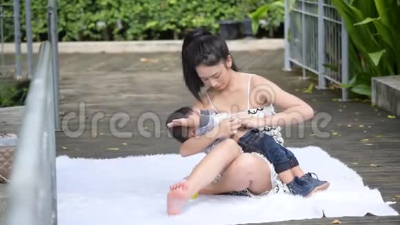亚洲单身母亲在花园里和小儿子玩耍视频的预览图