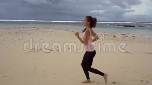 身材苗条的年轻女子在日出时在海上慢跑视频的预览图