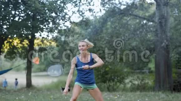 美丽的微笑运动健身女子在公园打羽毛球视频的预览图