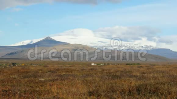 冰岛古老的冰川在阳光明媚的天气下云层在顶部秋天从干燥的田野上观看视频的预览图