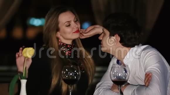 在黑暗餐厅的背景下美女亲吻男人额头的特写镜头视频的预览图