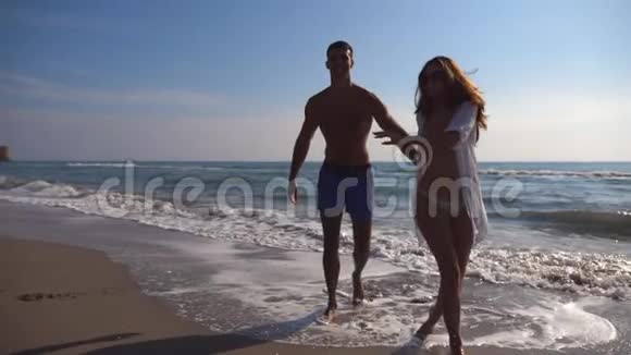 美丽的微笑情侣在海边散步情侣们一起度假玩得很开心爱和爱的概念视频的预览图