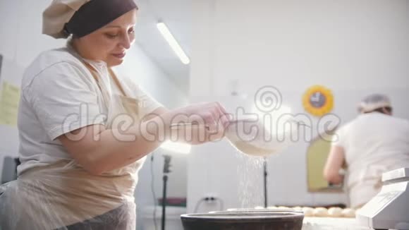 在面包房里用全生长的面粉和糖装饰烘焙产品视频的预览图
