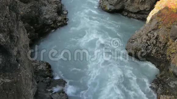 在坚硬的黑色岩石之间快速的山河流动戏剧性的镜头视频的预览图