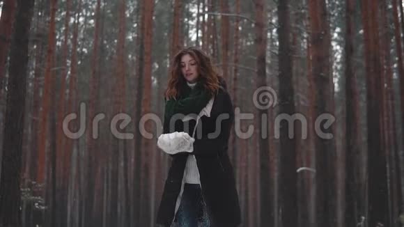 红发女孩把雪扔上去笑了头发上有雪花慢动作视频的预览图