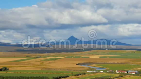 农田蜿蜒的河流和黑暗的高山背景冰岛的风景视频的预览图