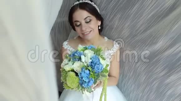 新娘的肖像手里拿着一束花靠近窗户视频的预览图