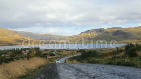 秋天一辆载着游客的汽车在冰岛美丽的山脉之间的公路上行驶视频的预览图
