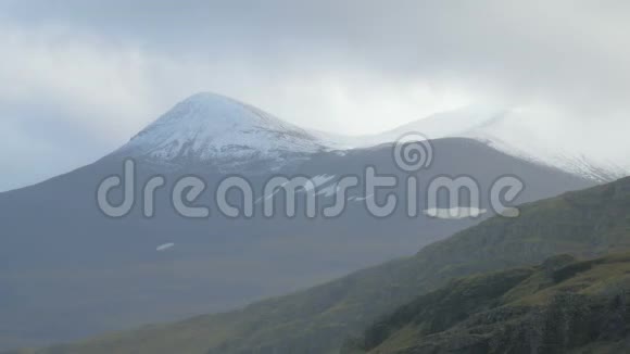 冰岛白雪皑皑的山脉山顶的特写多雨的云层正在移动视频的预览图