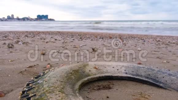 暴风雨中汽车轮胎在沙岸被波浪抛掷轮胎上布满了贝壳视频的预览图