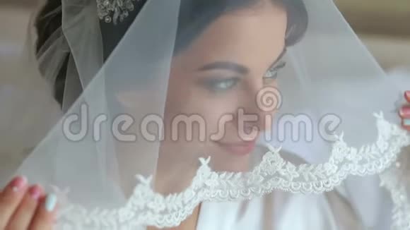 美丽的女人为婚礼做准备拿着面纱微笑着视频的预览图