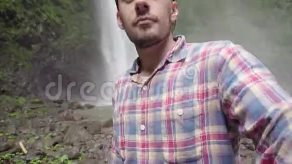 自私的男人男子在公园瀑布附近拍照视频的预览图