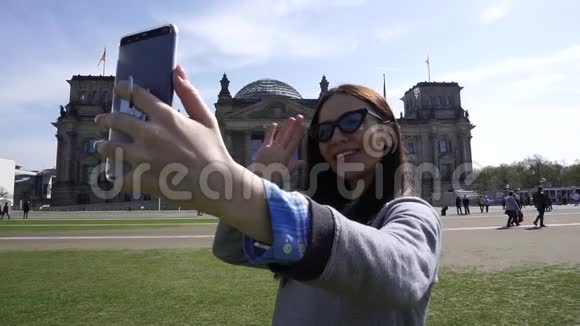 柏林帝国大厦智能手机上的快乐旅行女性视频通话视频的预览图