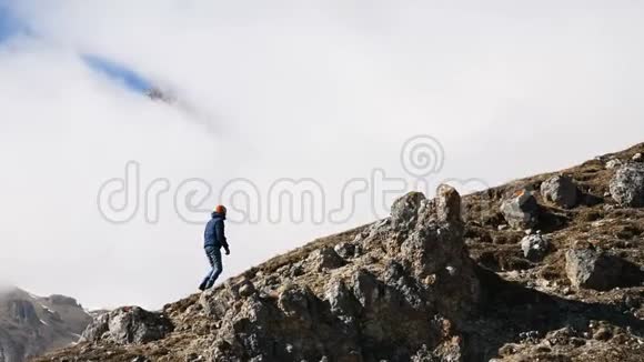 戴着帽子太阳镜脖子上戴着相机的胡子男摄影师爬上了山坡视频的预览图