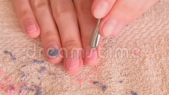 女人用推杆从指甲里取出紫胶特写的手顶部视图视频的预览图