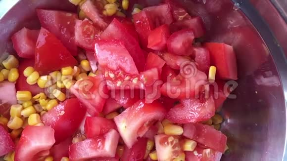 漂亮的新鲜蔬菜玉米和番茄掉进碗里慢动作视频的预览图