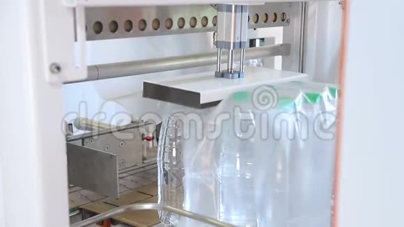 自动包装塑料瓶与薄膜在温度压力机进一步包装瓶子视频的预览图