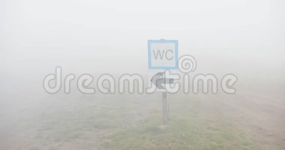 雾天街道指示牌山上覆盖着雾的WC标志的特写视频的预览图
