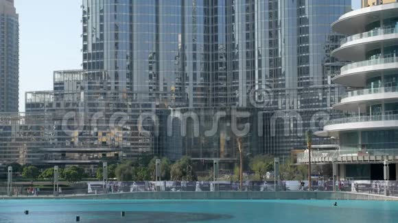 迪拜晴天喷泉附近的现代玻璃和混凝土建筑视频的预览图