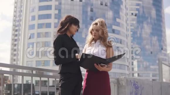 商务中心背景下的商务合作伙伴非正式会议两个正式西装的女商人视频的预览图