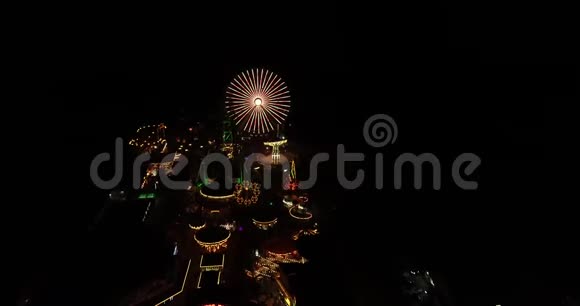 木板路游乐码头夜间无人机拍摄的空中录像灯光明亮天空漆黑视频的预览图
