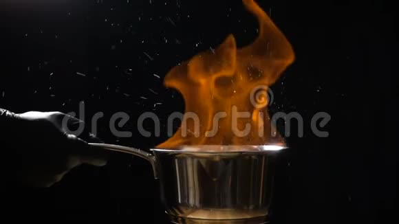 用燃烧的酱汁搅拌锅的手视频的预览图