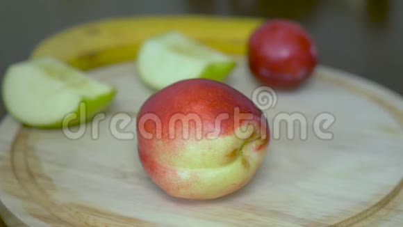 甜鲜美油桃这个人把它切成两个相等的部分特写在木质背景上视频的预览图