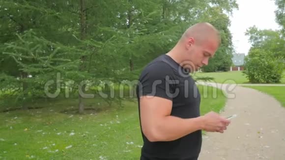 帅哥在公园户外使用手机侧视慢动作视频的预览图