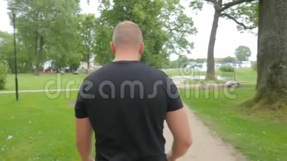 年轻的肌肉男在公园里用智能手机拍照视频的预览图