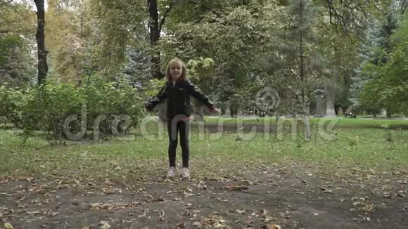 可爱的金发女孩在公园里跳起来把空气吻送到相机上视频的预览图