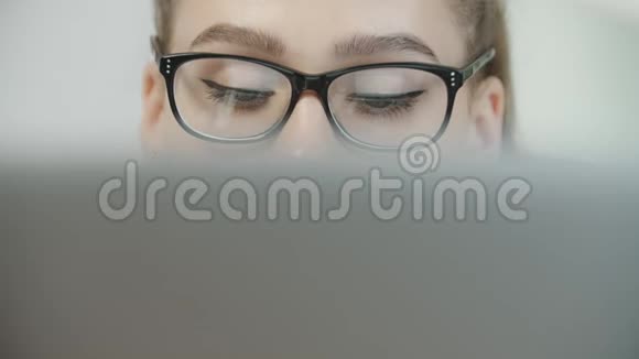 一个十几岁的学生戴着眼镜用笔记本电脑打字准备考试或家庭作业视频的预览图