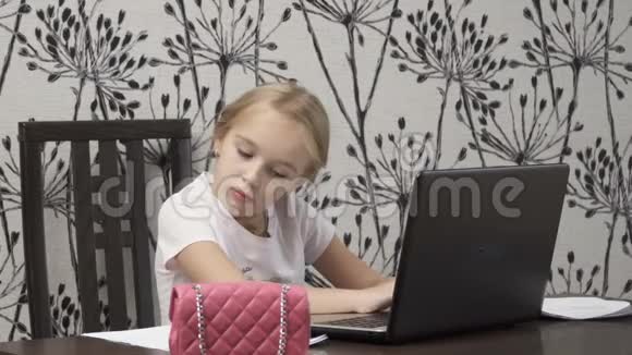 漂亮的小女孩用笔记本电脑工作视频的预览图