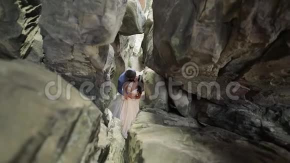 新郎新娘站在山上的山洞里新婚夫妇相爱视频的预览图