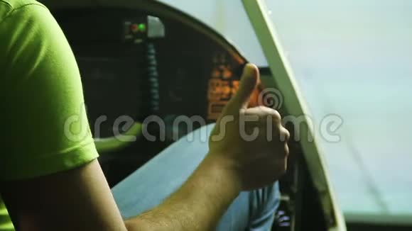 男青少年坐在飞机驾驶舱模拟器上显示OK手势视频的预览图