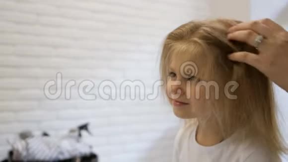 发型师理发师在美容院为一个可爱的小女孩做发型美发理发视频的预览图