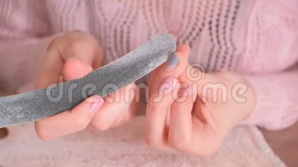 女人在去除虫胶之前用指甲锉擦指甲用刷子把灰尘抖掉特写双手视频的预览图