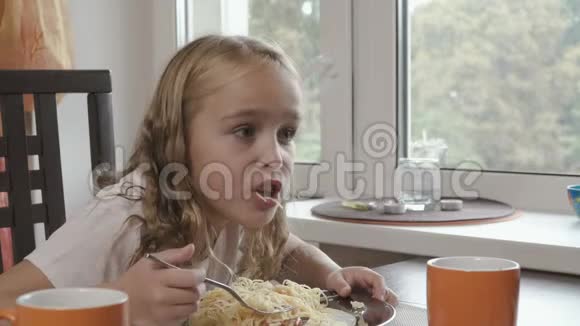 漂亮的小女孩在厨房里吃晚饭视频的预览图