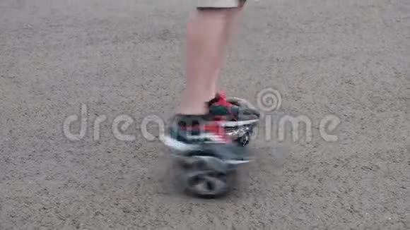 少年骑在一个自平衡的两轮气垫板上围成一个圆圈在沥青上运动生活方式两条腿很近视频的预览图