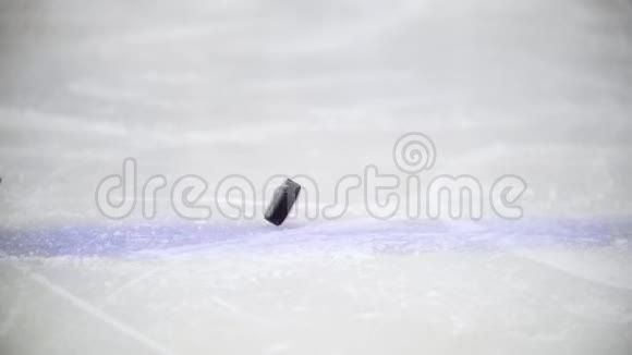 黑色冰球在冰球场的冰上旋转视频的预览图