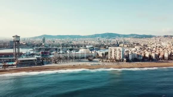 美丽的海滨城市现代化的建筑绿松石的海浪和人们在蓝天的沙滩上散步视频的预览图