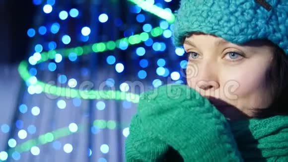 一个微笑的女孩正在圣诞树旁边喝茶视频的预览图