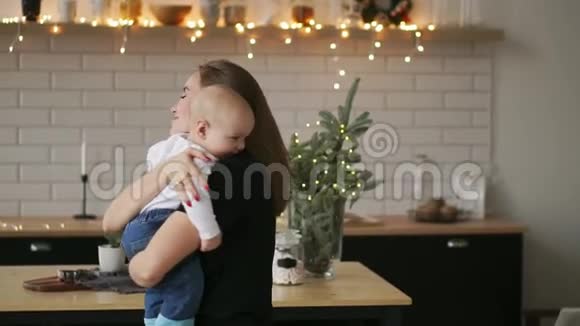 年轻的母亲抱着她新生的孩子慢动作家里的家人妈妈和孩子过圣诞节视频的预览图