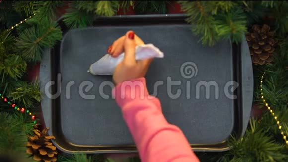 圣诞快乐在烤盘上涂奶油的女性手写字视频的预览图