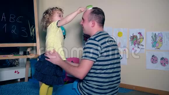 快乐的小女孩梳头梳头父亲半秃头视频的预览图